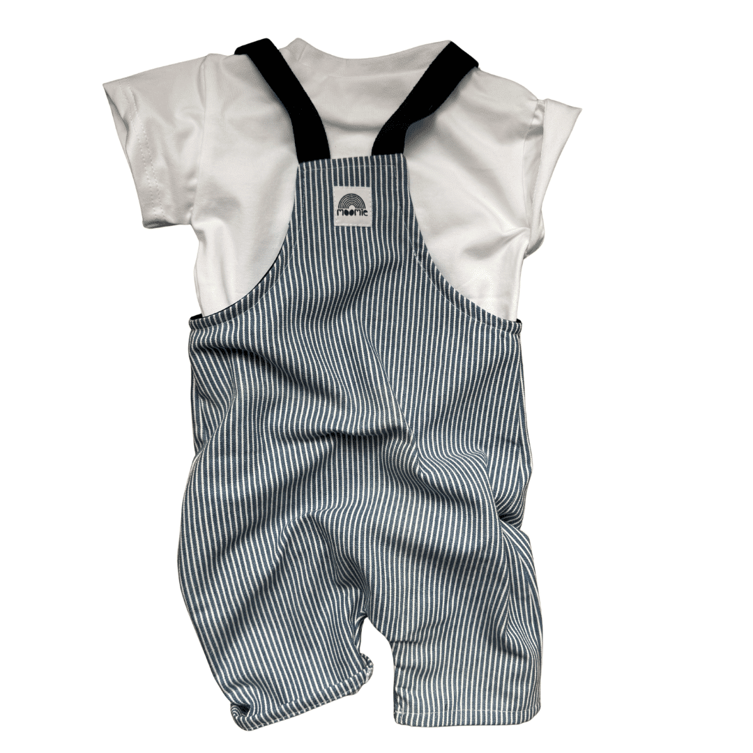 Salopette courte bébé rayée bleu et écru portée avec un t-shirt blanc, fabrication française Moomie