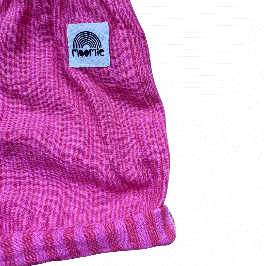 Zoom sur couture et tissu du short bébé en gaze de coton rayé fuchsia et rose
