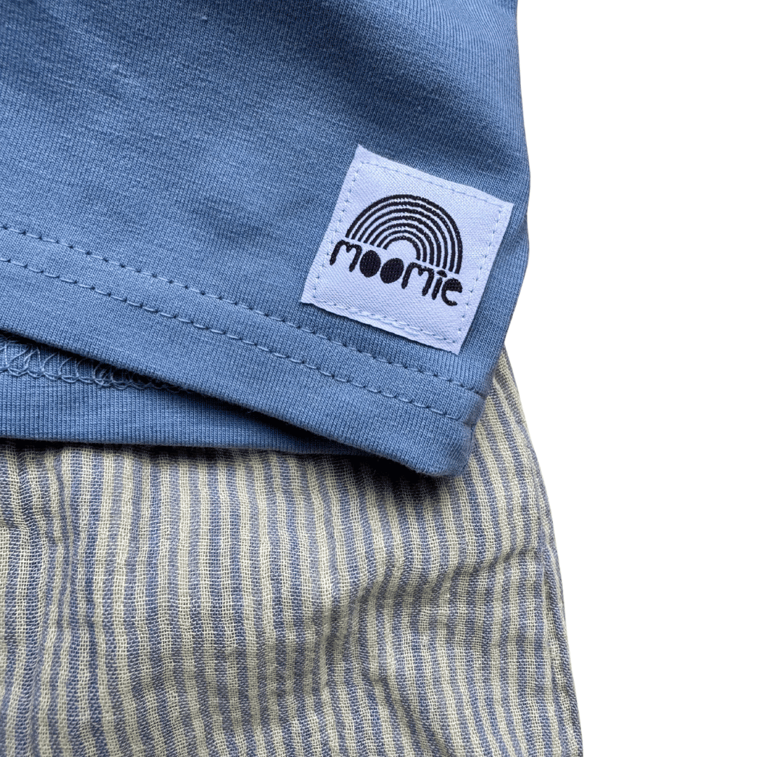 Zoom sur étiquette et tissu short bébé en gaze de coton rayé bleu et jaune