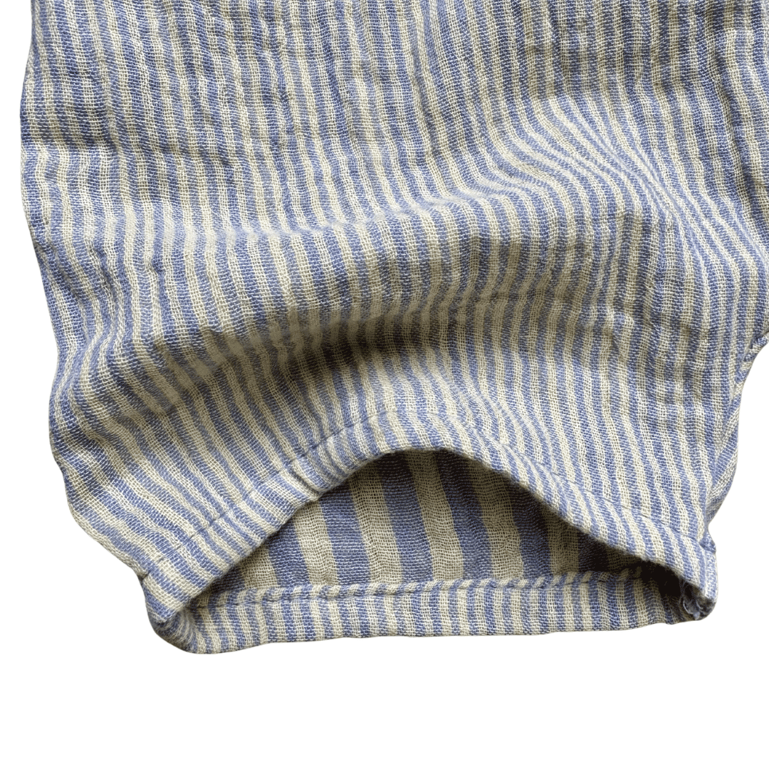 Détail tissu gaze de coton rayé bleu grisé et jaune pâle du short bébé