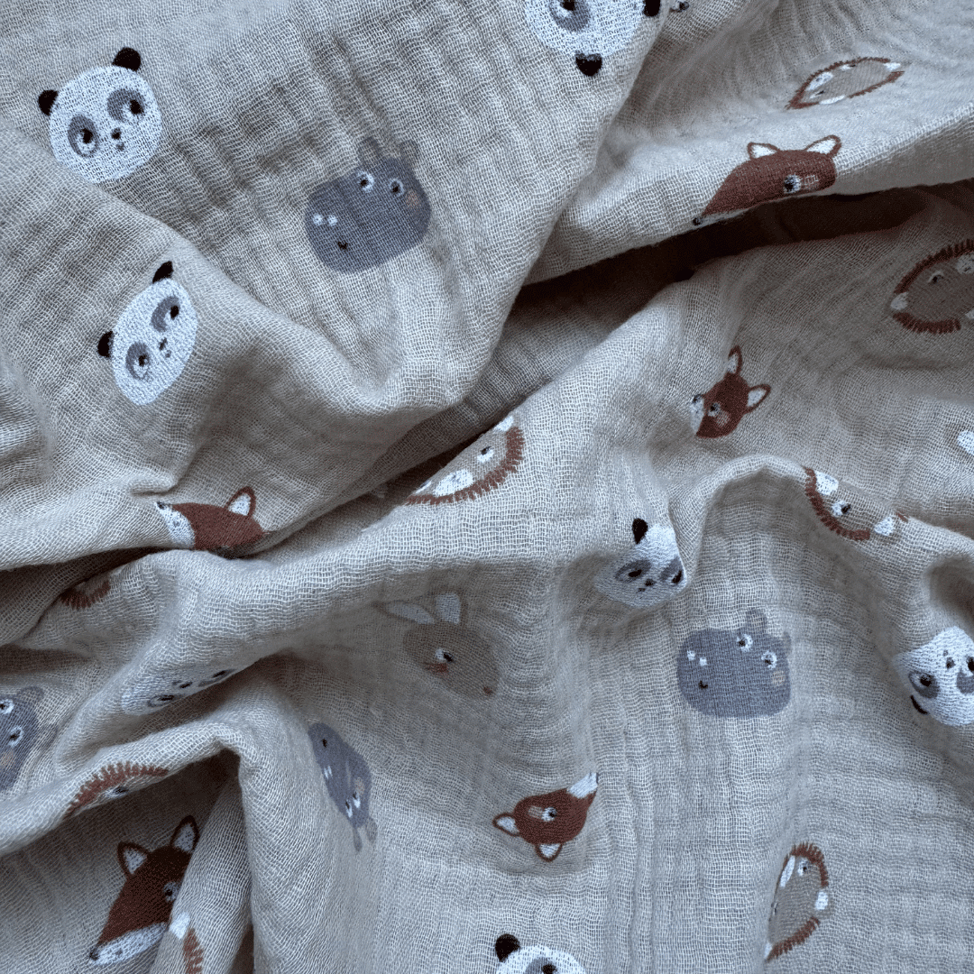 Gros plan sur la gaze de coton douce du lange bébé Lison avec imprimé panda, lion, renard et hippopotame.