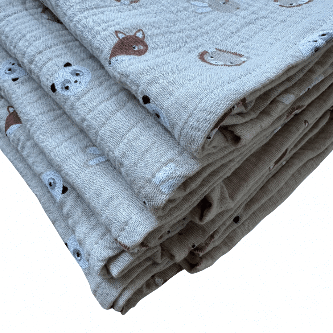 Plusieurs langes bébé Lison en gaze de coton beige pliés, imprimé petits animaux, confection française Moomie.