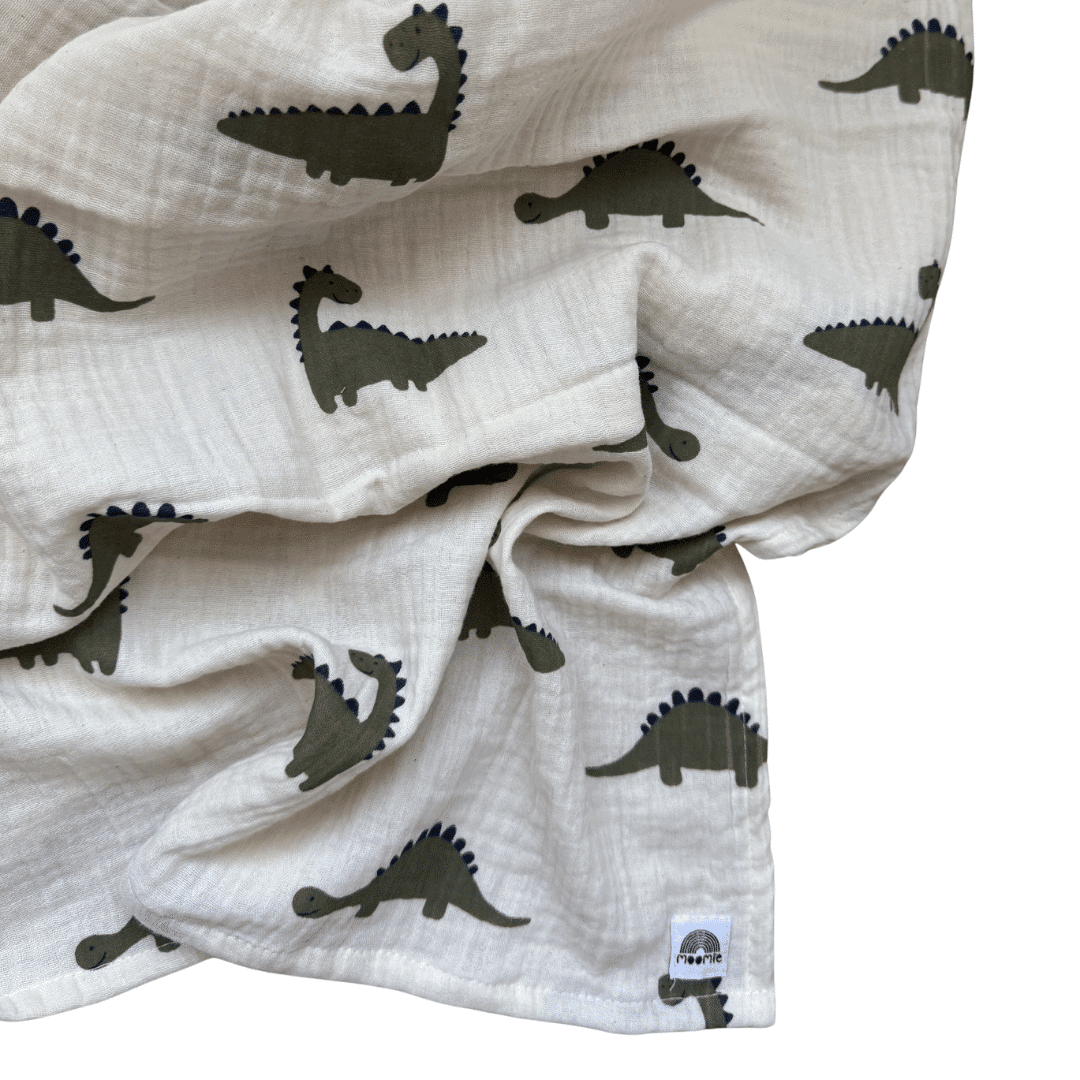 Détail du tissu en gaze de coton bio du lange Dinosaure Moomie avec imprimé dinosaures kaki et bleu marine