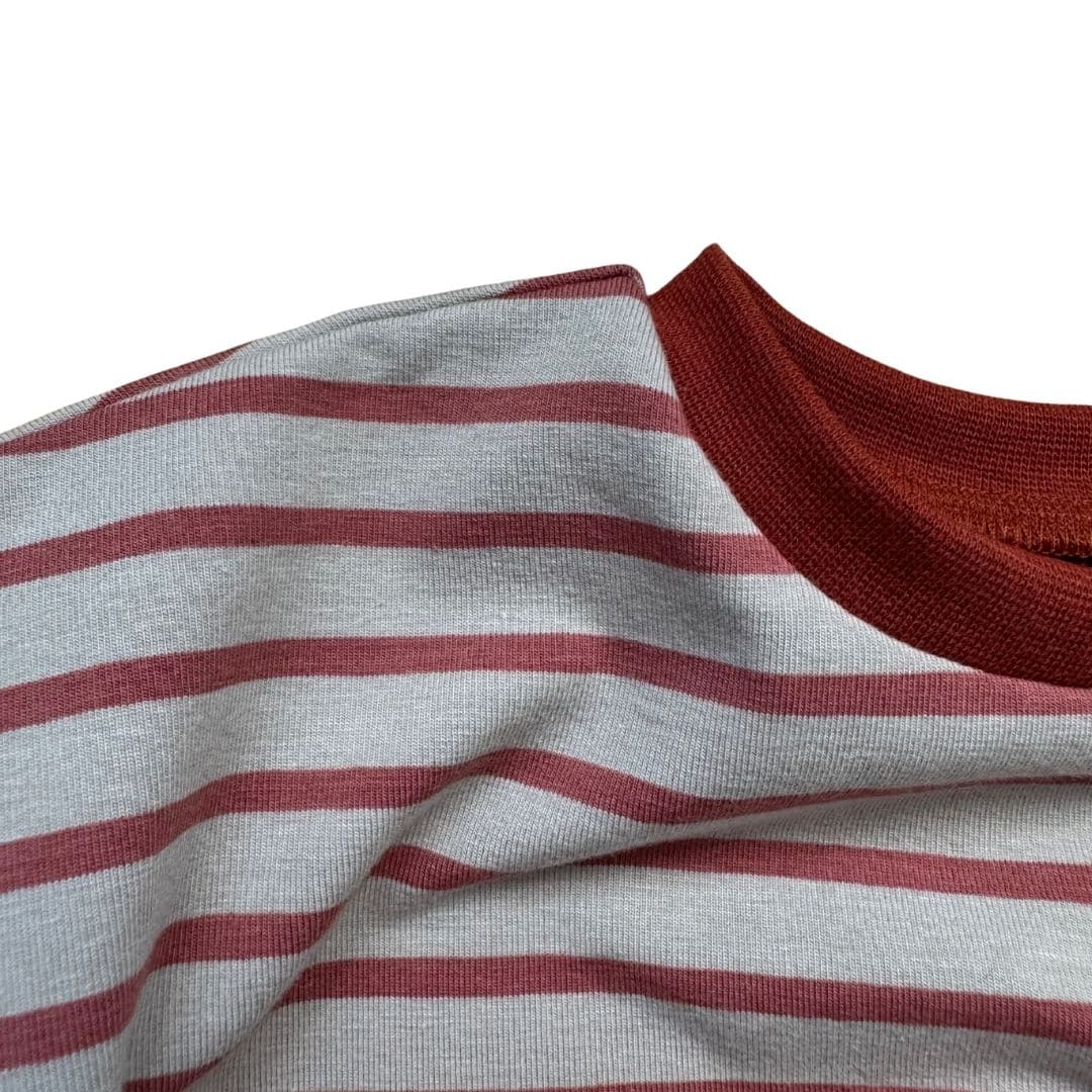 Détail du col terracotta et du jersey rayé crème du t-shirt bébé Moomie