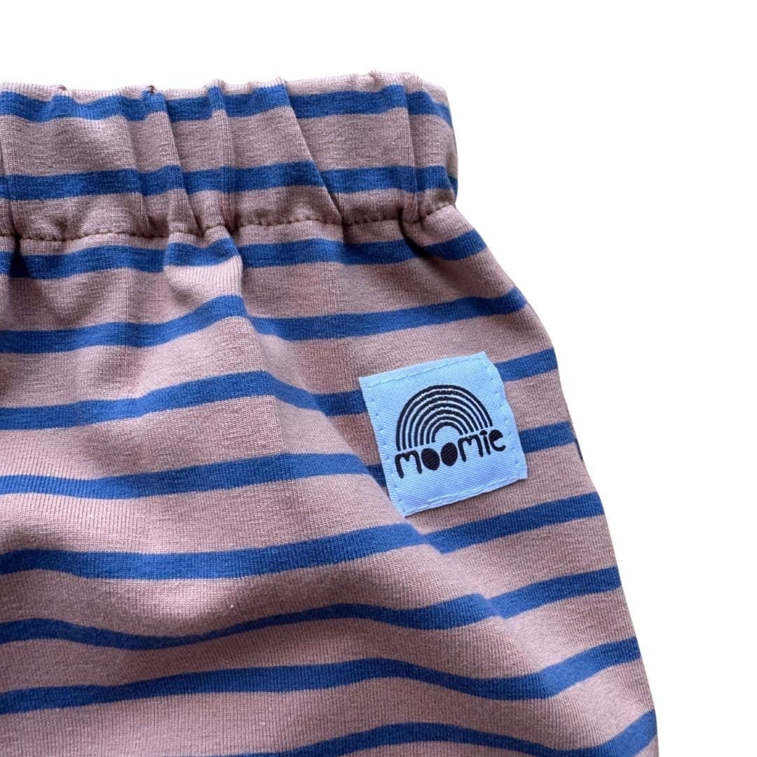 Détail de la taille élastiquée et de l'étiquette Moomie du pantalon rayé rose et bleu