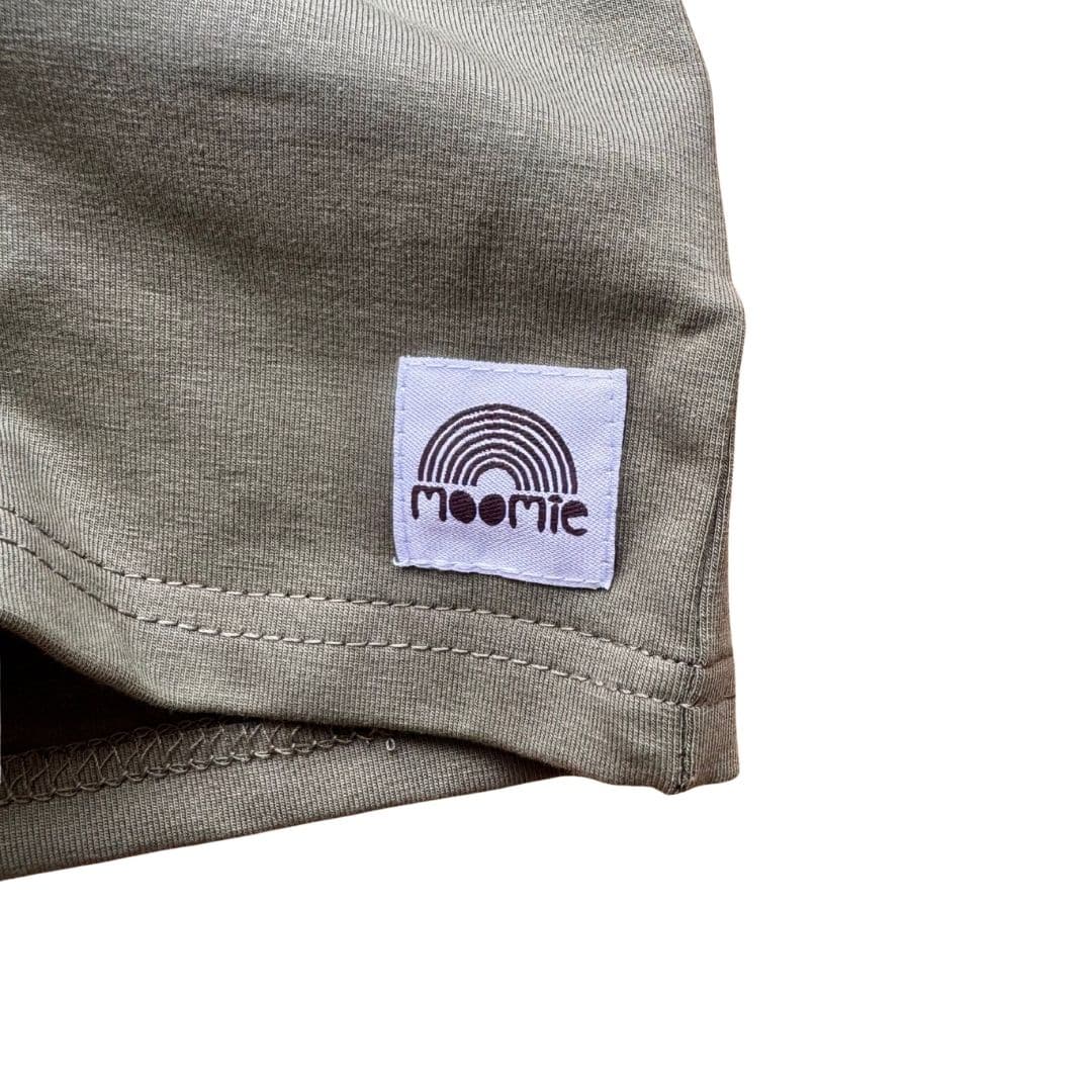 Détail du jersey kaki et de l’étiquette Moomie sur le t-shirt bébé manches longues