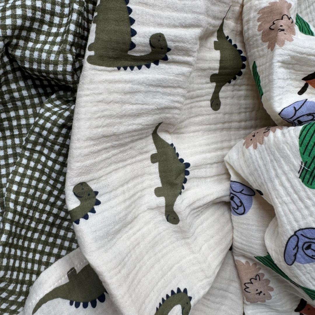 Détail des motifs dinosaures, animaux et vichy kaki des langes Petit aventurier