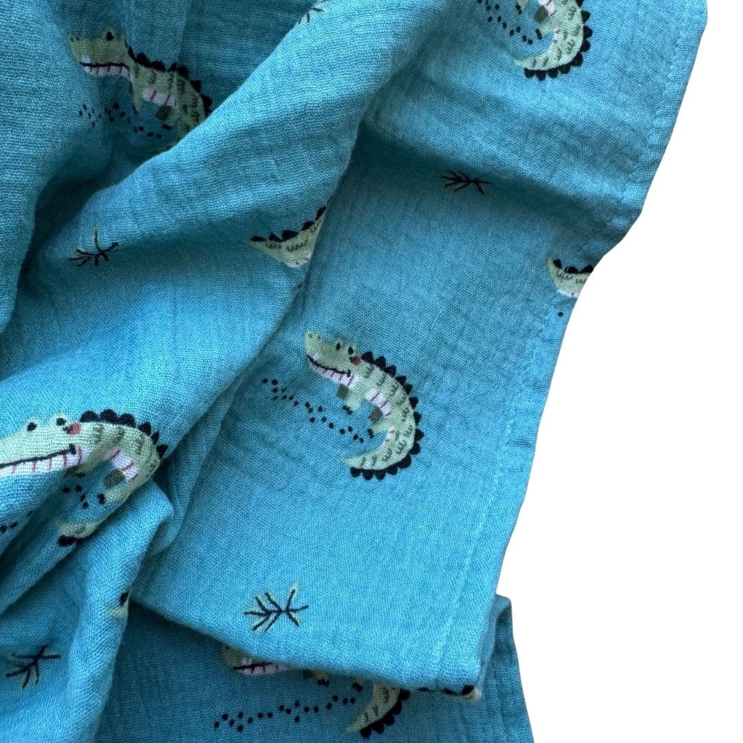 Lange en gaze de coton bleu canard avec petits crocodiles 4 – gros plan matière detail-lange-crocodile-gaze-coton.jpg Détail du lange Crocodile en gaze de coton Détail de la gaze de coton et du motif crocodile du lange Moomie Pour l'image principale Je choisirais la photo n°1, celle avec les langes empilés. Elle fonctionne vraiment bien en vignette WooCommerce : fond blanc, produit très lisible, joli volume et étiquette Moomie visible. Et c'est parfait pour le SEO : votre expression clé “lange bébé crocodile” apparaît naturellement dans le nom de la photo principale, son titre et son ALT, sans la répéter artificiellement sur les quatre images.