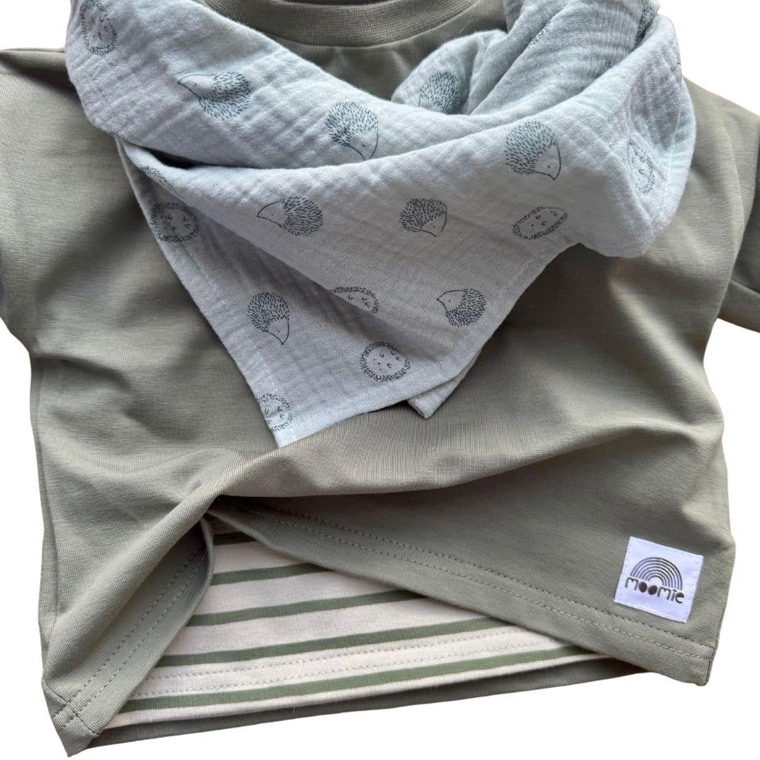 Lange bébé hérisson vert sauge en gaze de coton porté en foulard avec une tenue kaki Moomie