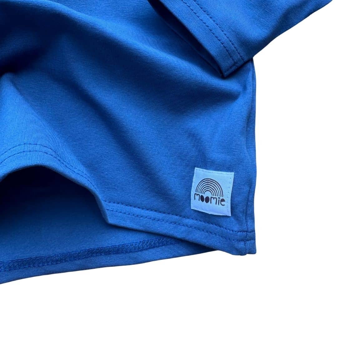 T-shirt bébé manches longues bleu uni Moomie, détail de l’étiquette et du jersey